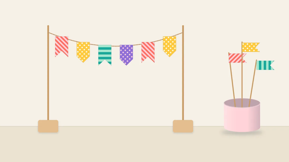 A mini banner of washi tape flags on twine strung between two wooden skewers, with three flag toppers on picks beside it