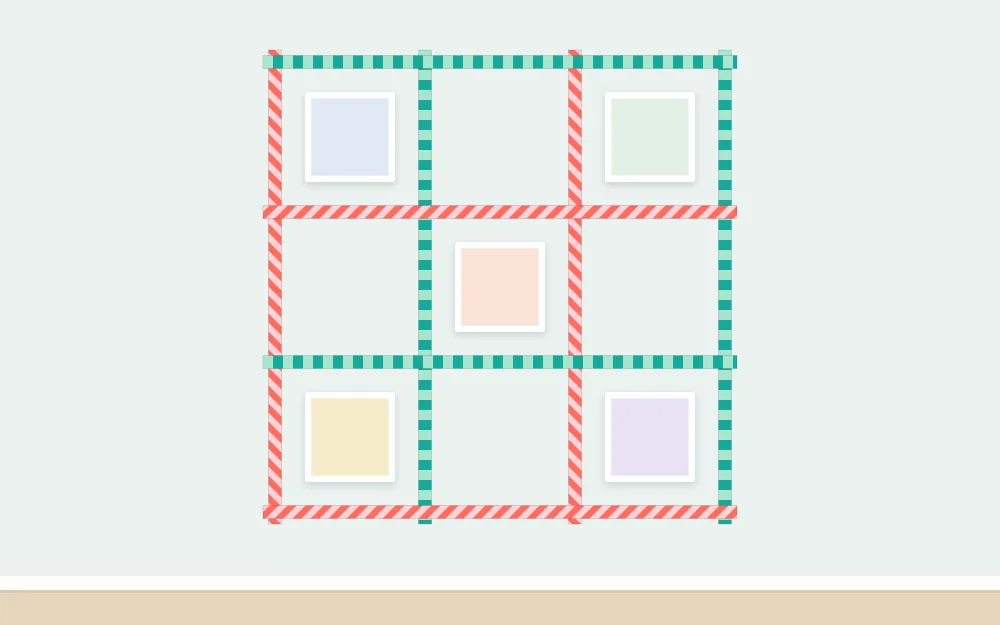 Wall with a three-by-three grid of tape squares, several holding small blank photo rectangles